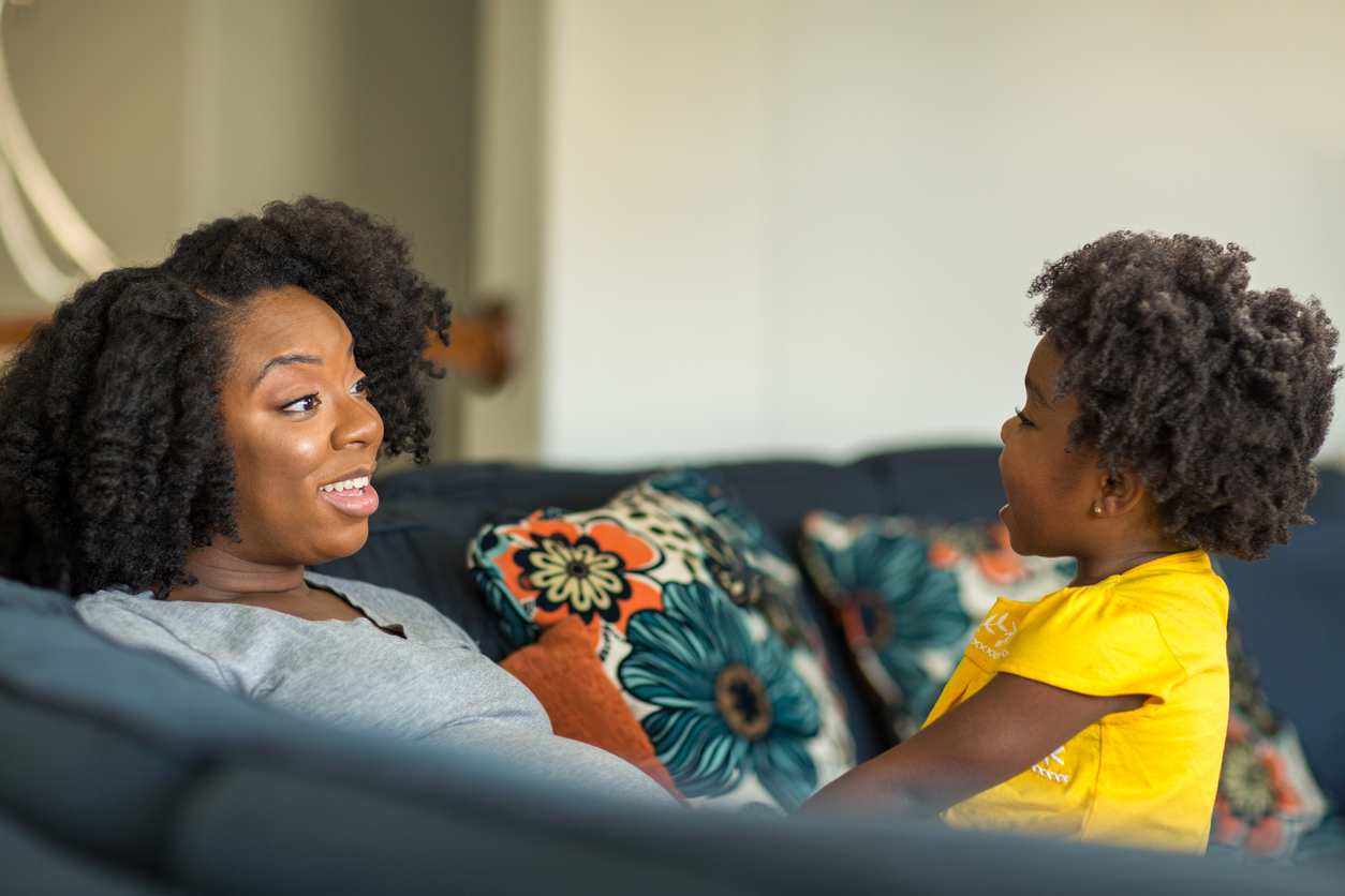 Mother and daughter talk on a couch