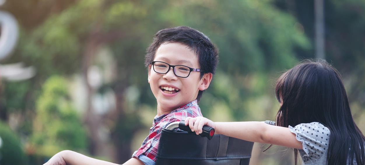 Sister pushes brother in wheelchair